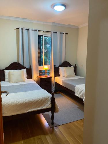 1 dormitorio con 2 camas y ventana en Apartamento Costa Do Sol V, en Funchal