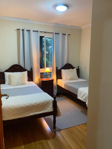 a bedroom with two beds and a window at Apartamento Costa Do Sol V in Funchal