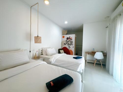 パックレにあるSTAYDII serviced residence Chaengwattanaのベッドルーム1室(ベッド2台、デスク付)