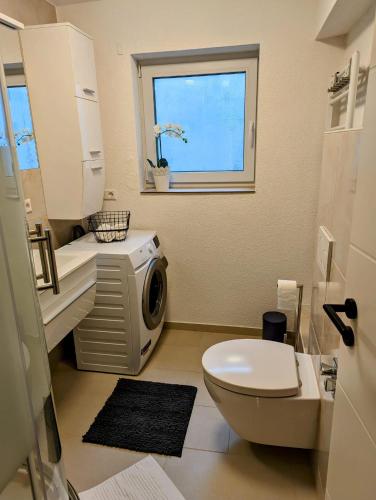 une salle de bain avec toilettes, lavabo et fenêtre dans l'établissement Bietigheimer Hideaway - Modern und Gemütlich, à Bietigheim