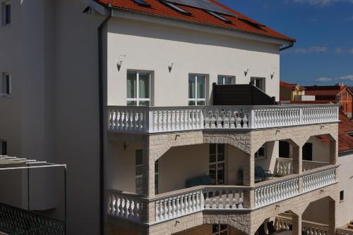 um grande edifício branco com uma grande varanda em Apartment R A M L J A K "Andrija" em Vodice