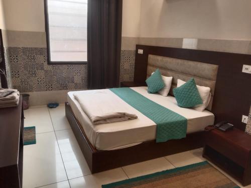 Pānīpat的住宿－Hotel Park Green，一间卧室配有带绿色和白色枕头的床