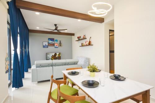 a dining room and living room with a table and chairs at Country Garden Seaview Suite by Nest Home at Danga Bay in Johor Bahru