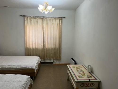 a bedroom with two beds and a window with a chandelier at Gana's Guest House and Tours in Ulaanbaatar