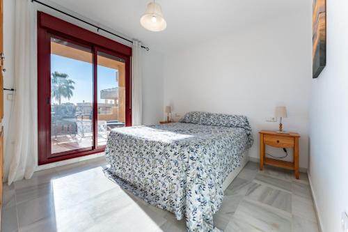ein Schlafzimmer mit einem Bett und einem Fenster in der Unterkunft 212 La Cala azul in La Cala de Mijas