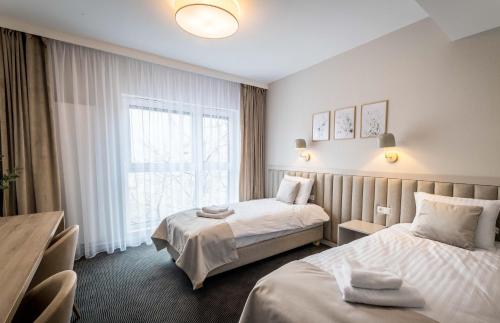 Habitación de hotel con 2 camas y ventana en Apartamenty Wolności 6 self check-in 24h en Poznan