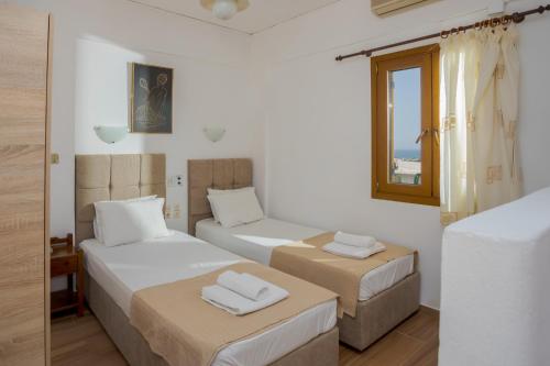 a room with two beds and a mirror at Bellino Apartments "Adults Only" in Hersonissos