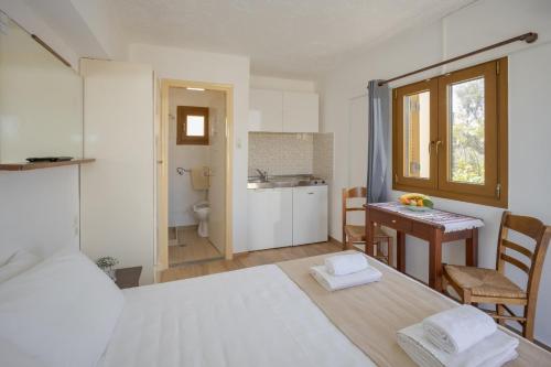 1 dormitorio con cama, mesa y cocina en Bellino Apartments "Adults Only" en Hersonissos