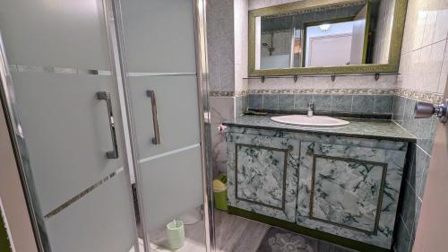 ein Bad mit einem Waschbecken, einem Spiegel und einer Dusche in der Unterkunft 5037 Sentosa 20B in Cap d'Agde
