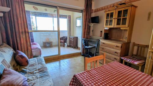 ein Wohnzimmer mit einem Sofa und einem Tisch sowie eine Küche in der Unterkunft 5037 Sentosa 20B in Cap d'Agde