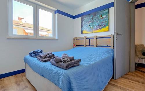 ein Schlafzimmer mit einem blauen Bett und Handtüchern darauf in der Unterkunft Sonia in Novigrad Istria