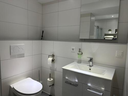 a white bathroom with a toilet and a sink at The perfect room in Karlsruhe