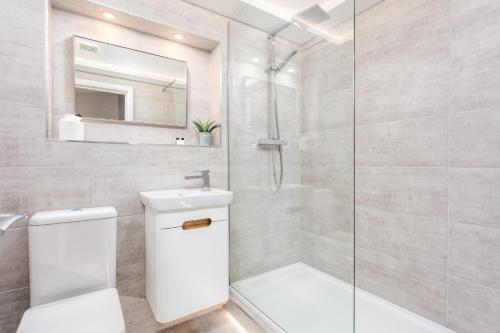 エアにあるBay View - Donnini Apartmentsのトイレとガラスのシャワー付きのバスルーム