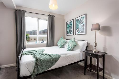 Schlafzimmer mit einem Bett und einem Fenster in der Unterkunft Bay View - Donnini Apartments in Ayr