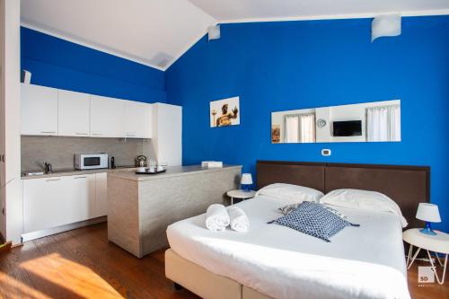 een blauwe kamer met een bed en een keuken bij Urbanicooh San Petronio - Torre Asinelli view in Bologna