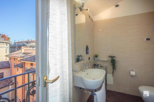 een badkamer met een wastafel en een balkon bij Urbanicooh San Petronio - Torre Asinelli view in Bologna