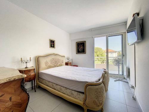 une chambre avec un lit et une grande fenêtre dans l'établissement Cannes - 3 pieces a 15mn Palais, à Cannes