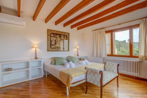 a bedroom with a bed and two chairs in it at Villa Zahara in Alcudia