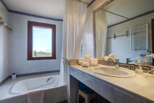 a bathroom with a sink and a tub and a mirror at Villa Zahara in Alcudia