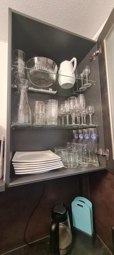 a shelf filled with plates and bowls and glasses at Koasablick in Ebbs