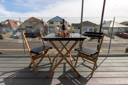 uma mesa numa varanda com 2 cadeiras e uma garrafa de vinho em BOURNECOAST: STYLISH FLAT WITH SEA GLIMPSES - FM8405 em Southbourne