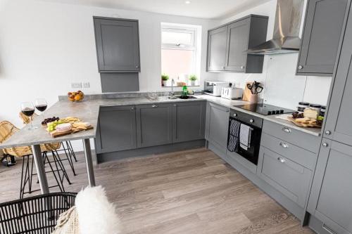 a kitchen with gray cabinets and a counter top at BOURNECOAST: STYLISH FLAT WITH SEA GLIMPSES - FM8405 in Southbourne