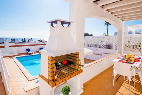 un patio con chimenea junto a una piscina en Villa Turtle Beach by Algarve Vacation, en Albufeira