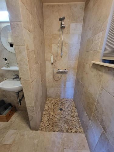 ein Bad mit einer Dusche und einem Waschbecken in der Unterkunft Rysselende Molen in Ardooie