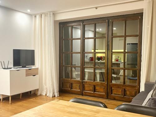 Apartamento Mirador Encamp في انكامب: غرفة معيشة مع خزانة خشبية كبيرة وتلفزيون