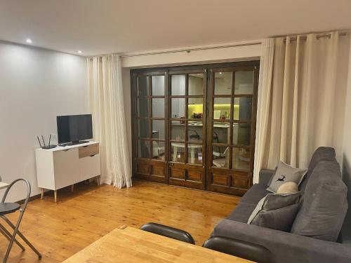 a living room with a couch and a television at Apartamento Mirador Encamp in Encamp