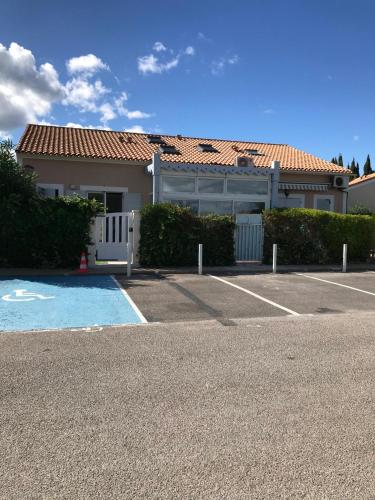 une maison avec un parking en face d'une maison dans l'établissement Charmante petite maison à proximité de la plage, à Palavas-les-Flots