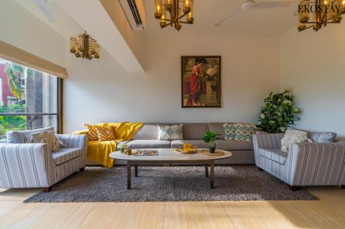 Sala de estar con 2 sofás y mesa de centro en EKOSTAY Luxe - Casa Marina, en Candolim