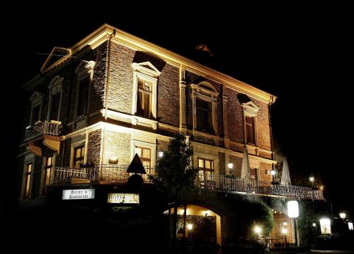 a large brick building with lights on it at night at Weinhotel St. Stephanus in Zeltingen-Rachtig