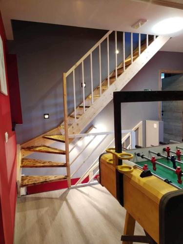 a room with a staircase with a table and a pool table at Le Coin Rocheux in La Roche-en-Ardenne
