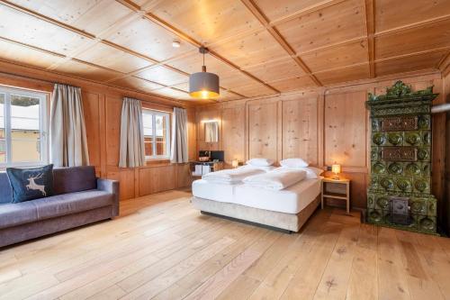 a bedroom with a bed and a couch at NATURPARKGUT - Apartment HOLZGAU1758 in Holzgau
