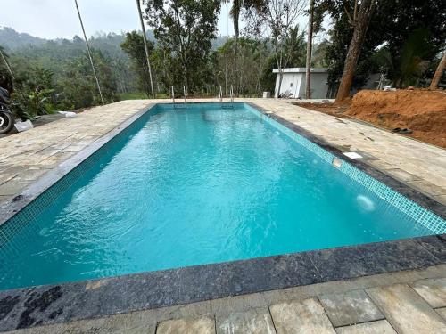 una piscina en una casa de agua azul en Silver Oak By Exuberance Stays (Independent Holiday Home), en Wayanad