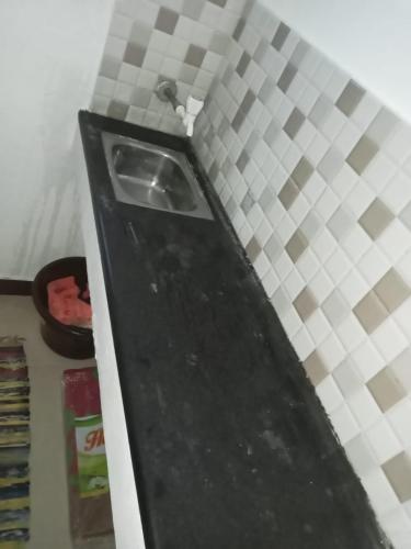 um balcão de cozinha com um lavatório num quarto em Trishul holidays em Alāndurai