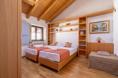 - 2 lits dans une chambre avec des étagères en bois dans l'établissement Apartment By the Ferry - Menaggio, à Menaggio