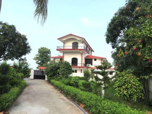 a house in the middle of a road at Flagship Corbett Farm Homestay in Rāmnagar