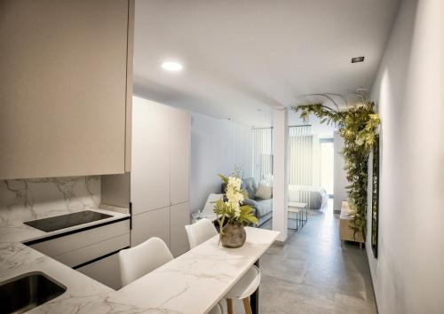 a kitchen with a table and chairs and a living room at Riam suites apartamentos in Los Palacios y Villafranca