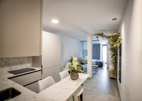 eine Küche mit einem Tisch und ein Wohnzimmer in der Unterkunft Riam suites apartamentos in Los Palacios y Villafranca