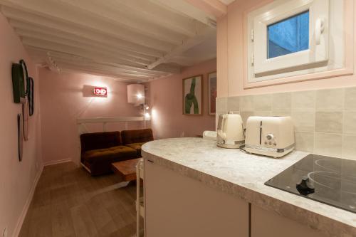 une cuisine avec un comptoir et un salon dans l'établissement Charmant duplex historique Cœur Marais, à Paris