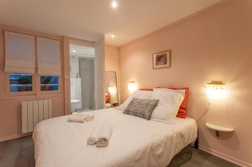 une chambre avec un grand lit avec des serviettes dessus dans l'établissement Charmant duplex historique Cœur Marais, à Paris