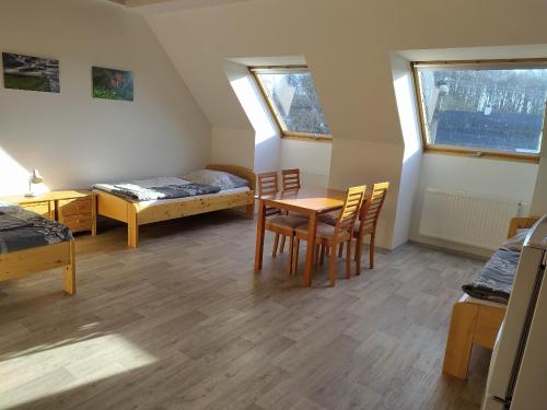 Cette chambre comprend une table, des chaises et un lit. dans l'établissement Apartmány Dalov, à Šternberk