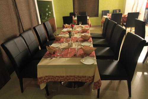 a dining room with a long table and chairs at Park Residency Airport Road in Kozhikode