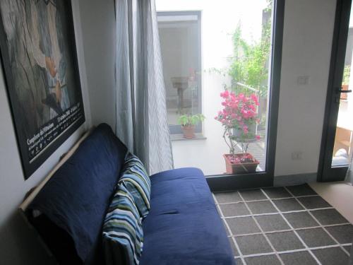 a blue couch in a living room with a window at Brancadoria B&B in Monteleone Rocca Doria