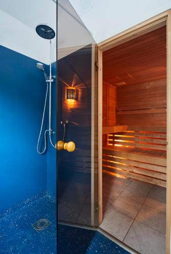 a sauna with a shower with a glass door at Nowa Stodoła in Kuligów