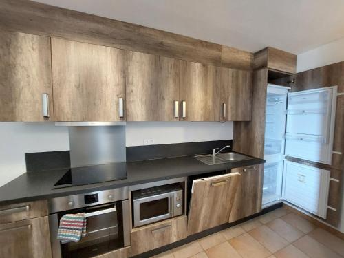 una cocina con armarios de madera y fregadero en Hellebore en Le Mas