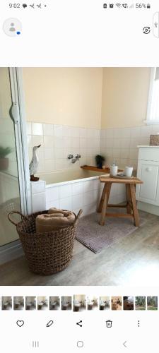 a bathroom with a table and a bath tub at HUNTER COTTAGE EUROA - "A great weekend escape" in Euroa