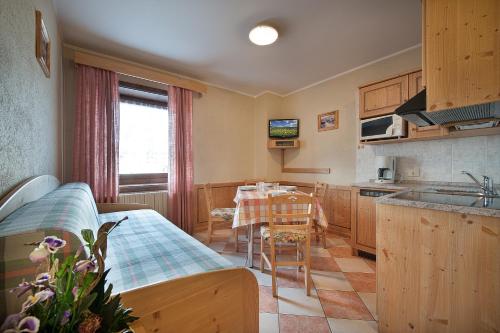 Appartamenti Bait Carosello في ليفينو: مطبخ مع طاولة وغرفة طعام